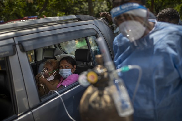 FILE - In this April 24, 2021, file photo, a patient receives oxygen inside a car provided by a Gurdwara, a Sikh place of worship, in New Delhi, India. Countries fighting new surges of the coronavirus ...