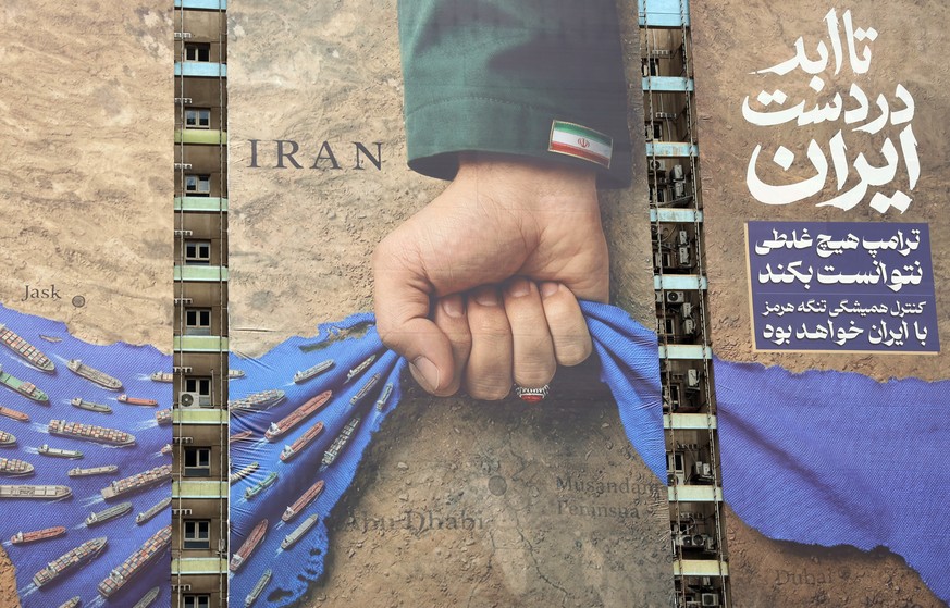epa12899726 A large-scale billboard referring to the Strait of Hormuz and reading in Persian, Forever on Irans hand, stands in a square in Tehran, Iran, 19 April 2026. Tensions between the United S ...