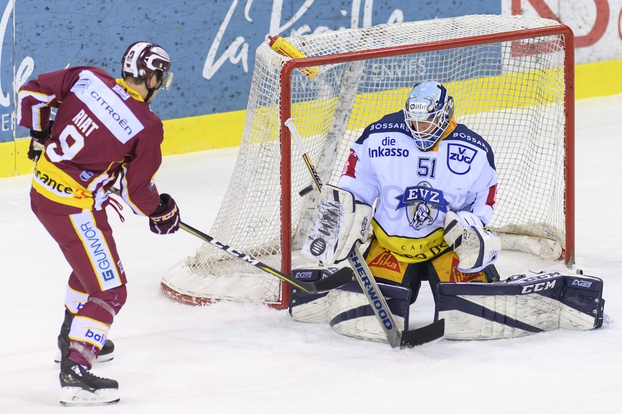 Le gardien zougois, Tobias Stephan, droite, a la lutte pour le puck avec le joueur genevois, Damien Riat, gauche, lors du match du championnat suisse de hockey sur glace de National League, entre le G ...