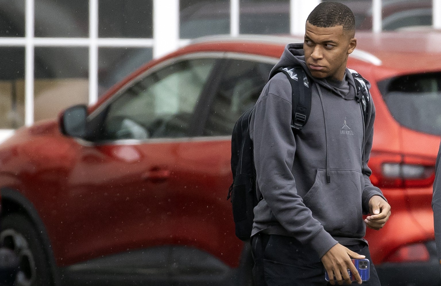 epa09311145 French striker Kylian Mbappe walks out of Le Bourget airport as the French national soccer team returns to France, in Le Bourget, outside Paris, France 29 June 2021. France was knocked out ...
