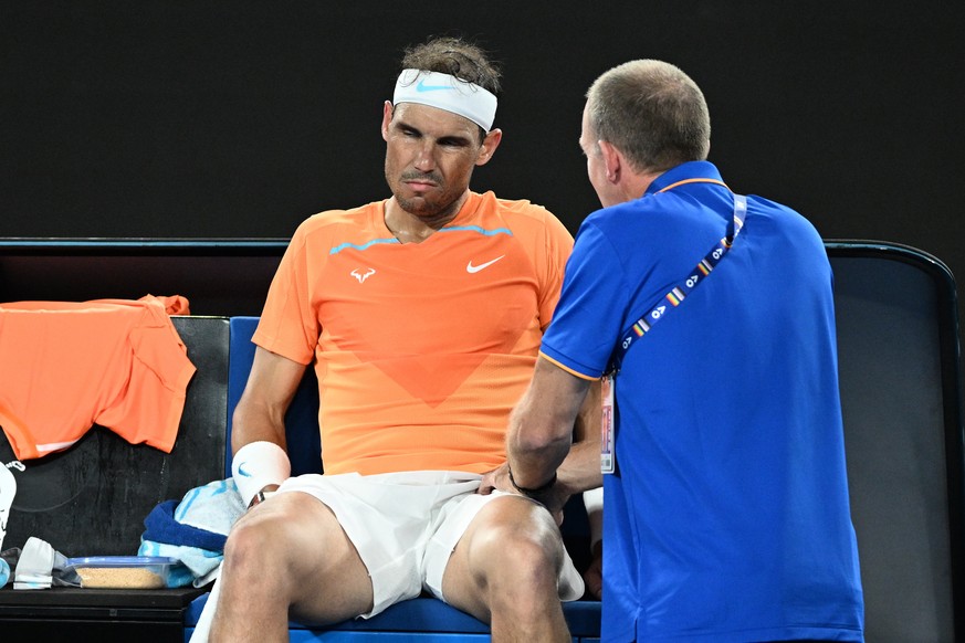 epa10412337 Rafael Nadal of Spain receives medical treatment in his match against Mackenzie McDonald of the USA during the 2023 Australian Open tennis tournament at Melbourne Park in Melbourne, Austra ...