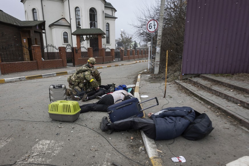 Ukrainian servicemen try to help people wounded, in the town of Irpin, Ukraine, Sunday, March 6, 2022. With the Kremlin&#039;s rhetoric growing fiercer and a reprieve from fighting dissolving, Russian ...