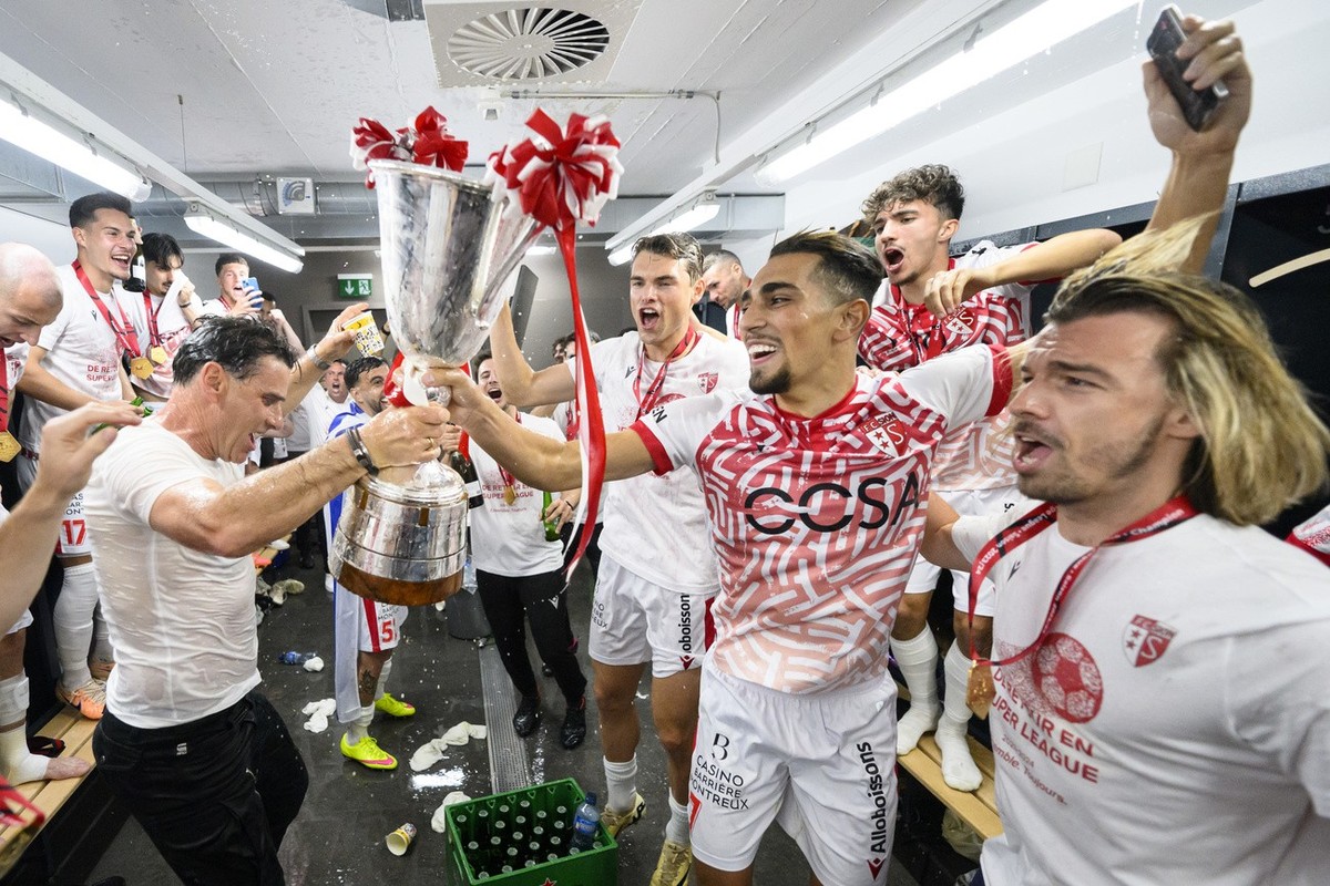 L'entraineur du FC Sion Didier Tholot, gauche, et ses joueurs de gauche a droite, Joel Schmied, Ilyas Chouaref et le directeur sportif Barthelemy Constantin celebrent avec la coupe de champion de ...