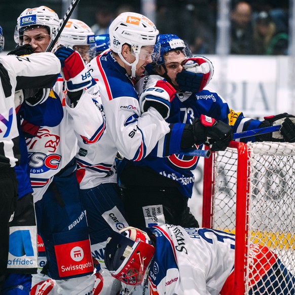 Juho Lammikko (ZSC), gauche, lutte pour le puck avec Sandro Schmid (HCFG), droite, lors du match du championnat suisse de hockey sur glace de National League entre le HC Fribourg Gotteron et les Zuric ...