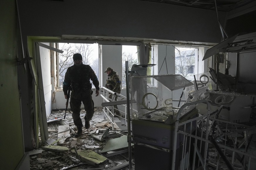 Ukrainian servicemen work inside of the damaged by shelling maternity hospital in Mariupol, Ukraine, Wednesday, March 9, 2022. A Russian attack has severely damaged a maternity hospital in the besiege ...