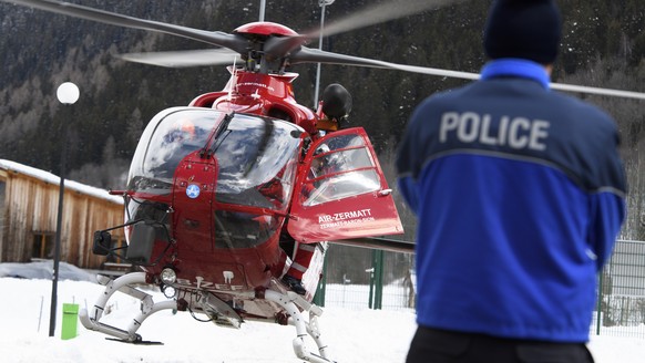 ARCHIV - ZUM VERMISSTEN DEUTSCHEN UNTERNHEMER KARL-ERIVAN HAUB STELLEN WIR IHNEN DIESES ARCHIVBILD ZUR VERFUEGUNG - A police officer looking at an Air Zermatt helicopte landing after research on the a ...