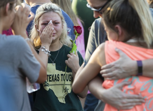 A woman wipes away tears during a prayer vigil following a shooting at Santa Fe High School in Santa Fe, Texas, on Friday, May 18, 2018. Seventeen-year-old Dimitrios Pagourtzis is charged with capital ...