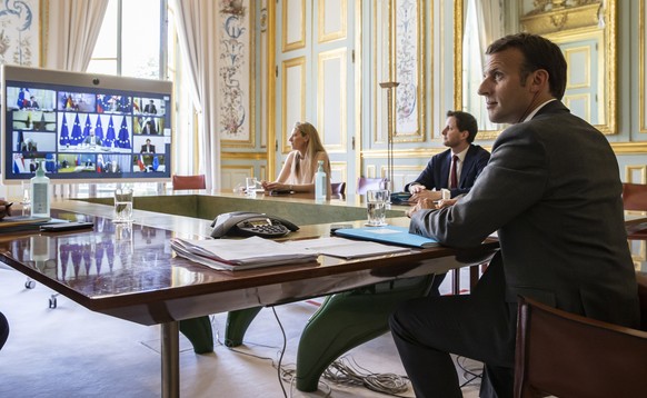 epa08379772 French President Emmanuel Macron (R) attends a video conference call with members of the European Council at the Elysee Palace in Paris, France, 23 April 2020. Countries around the world a ...