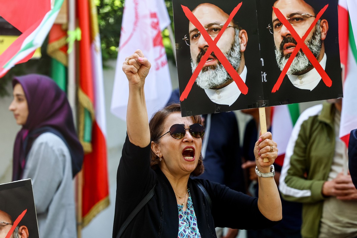 epaselect epa11355183 A protester holds a placard against Iran's President Ebrahim Raisi during a protest of the National Council of Resistance of Iran (NWRI) against the Iranian regime in front  ...