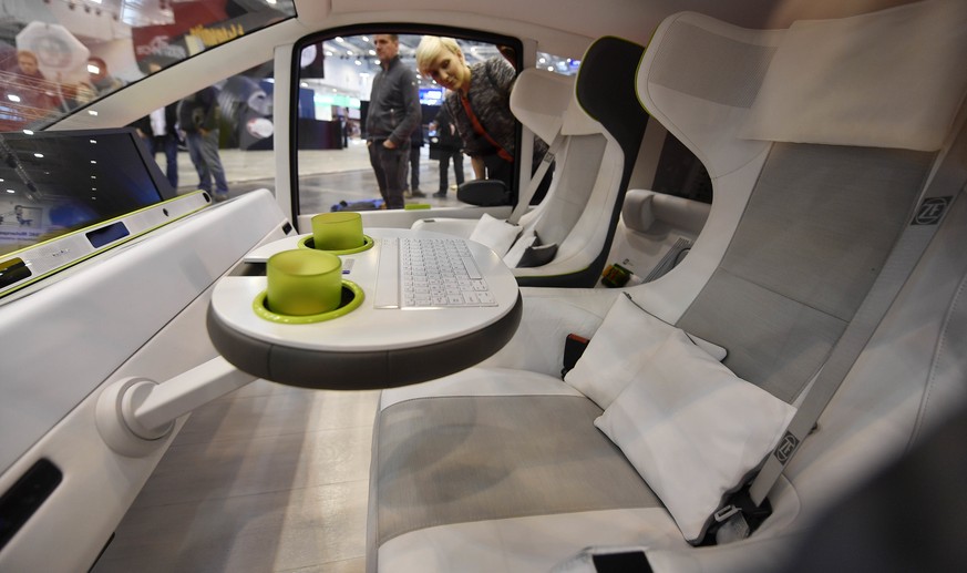 A woman looks into the self driving concept car Rinspeed Oasis at a preview of the Motor Show in Essen, Germany, Wednesday, Nov. 29, 2017. The international car performance festival starts Friday for  ...