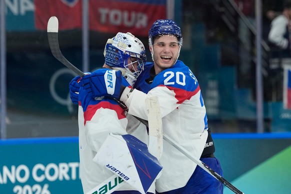 Slovakia's goalkeeper Samuel Hlavaj, left, celebrates with his teammate Slovakia's Juraj Slafkovsky end of a preliminary round match of men's ice hockey between Sweden and Slovakia at t ...