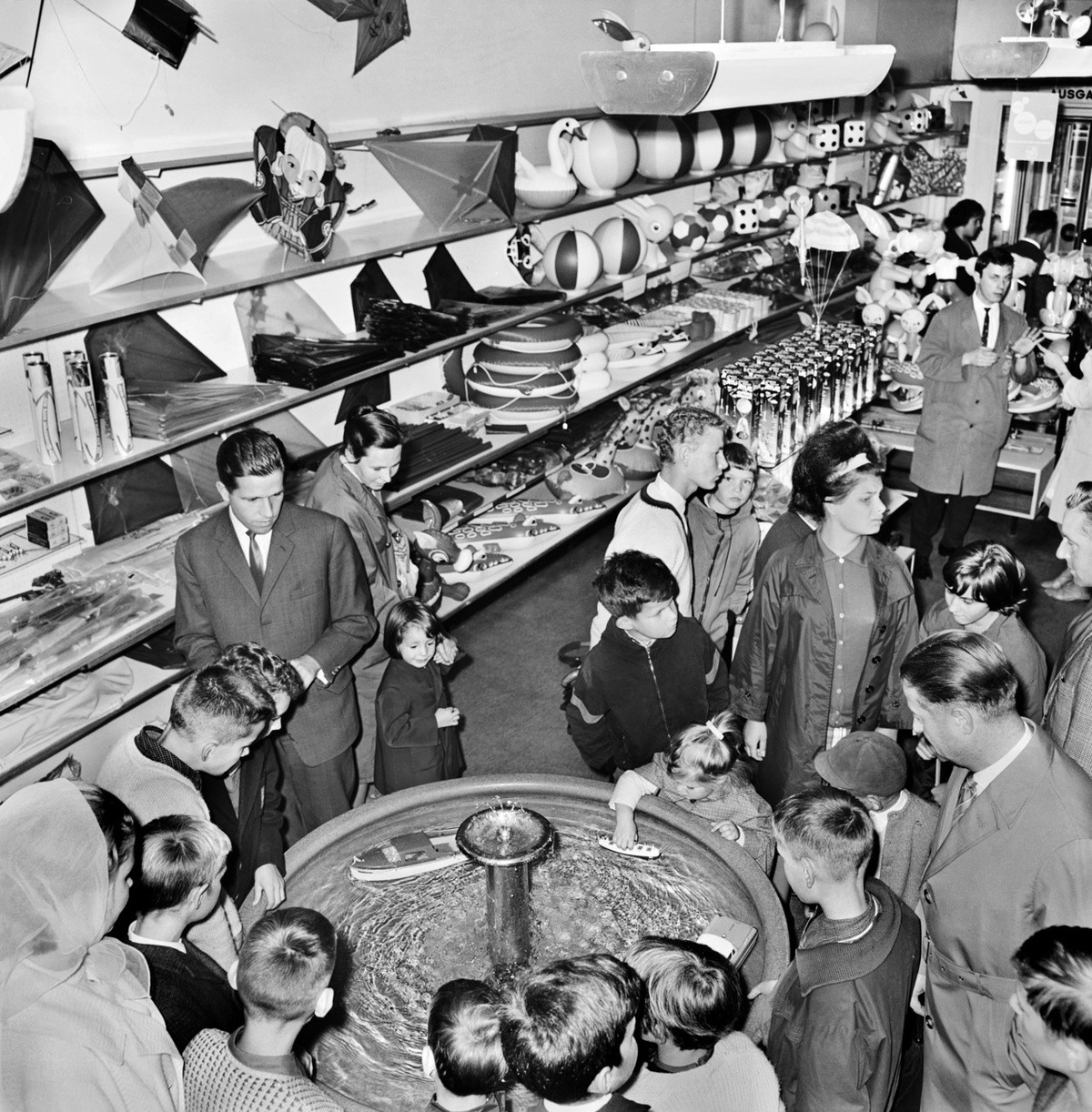 Kinder und Erwachsene bestaunen im Spielwarengeschaeft Franz Carl Weber an der Bahnhofstrasse in Zuerich im August 1963 das Wasserbassin mit den Spielzeugschiffchen. (KEYSTONE/PHOTOPRESS-ARCHIV/Str)