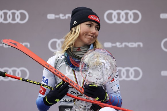 United States&#039; Mikaela Shiffrin celebrates on the podium with the trophy for the alpine ski women&#039;s overall World Cup title, in Meribel, France, Sunday, March 20, 2022. (AP Photo/Alessandro  ...