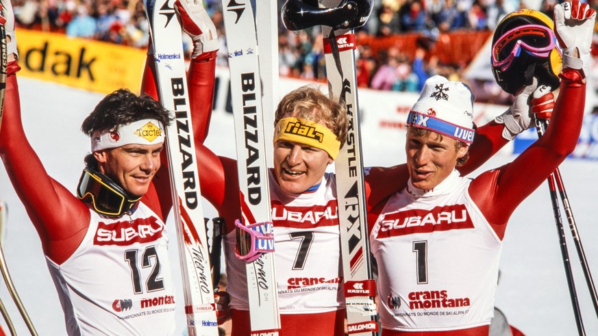 Die Schweizer Herren Ski Nationalmannschaft erlebte an der Ski Weltmeisterschaft in Crans-Montana 1987 einen dreifachen Triumph. Peter Mueller, Mitte, gewinnt die Abfaht vor Pirmin Zurbriggen, rechts, ...