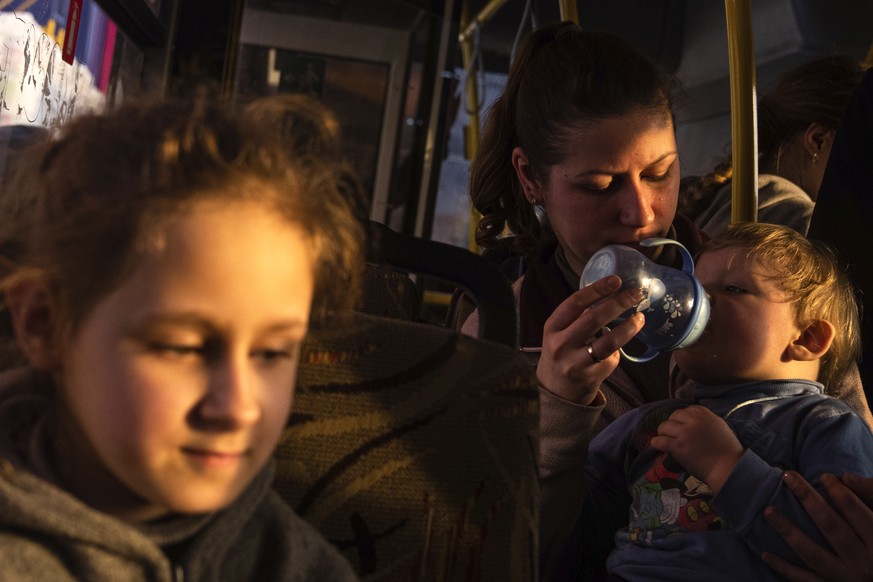 People with children wait after arriving from the Ukrainian city of Mariupol at a center for displaced people in Zaporizhzhia, Ukraine, Tuesday, May 3, 2022. (AP Photo/Evgeniy Maloletka)