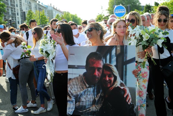 Veronique Monguillot, wife of Philippe Monguillot, a bus driver who was attacked in Bayonne on Sunday night, holds a photo of her with her husband, during a protest march in Bayonne, southwestern France, Wednesday, July 8, 2020.  Monguillot was left brain dead after being attacked by passengers who refused to wear face masks. (AP Photo/Bob Edme)