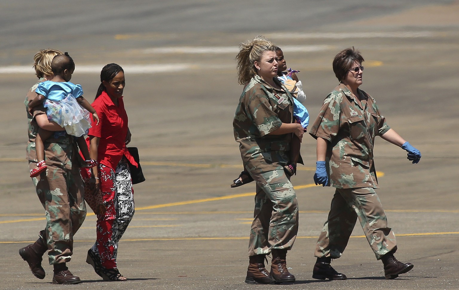Südafrikanische Überlebende des Unglücks treffen, begleitet vom südafrikanischen Militär, in Johannesburg ein.