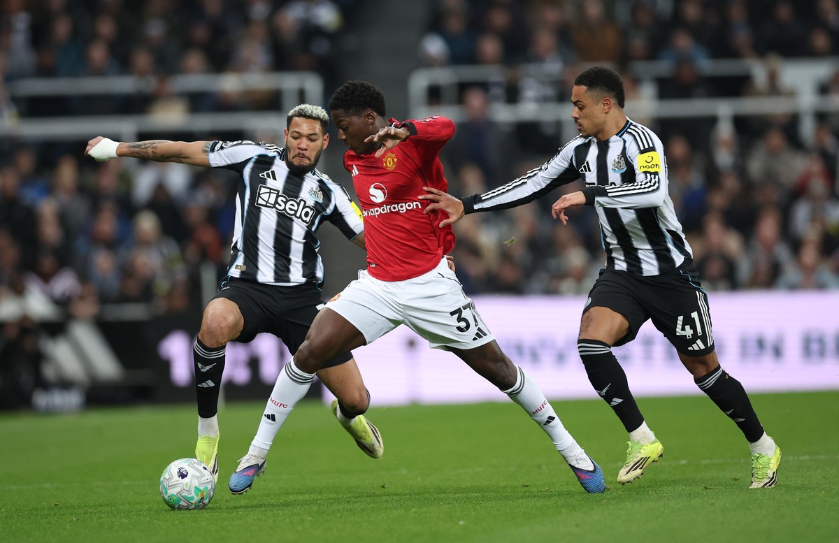 epa12795275 Kobbie Mainoo of Manchester United (C) in action against Joelinton (L) and Jacob Ramsey of Newcastle United (R) during the English Premier League match between Newcastle United and Manches ...