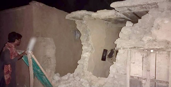 A local resident looks his damaged house following a severe earthquake hit the area, in Harnai, about 100 kilometers (60 miles) from Quetta, Pakistan, Thursday, Pakistan. A powerful earthquake shook p ...