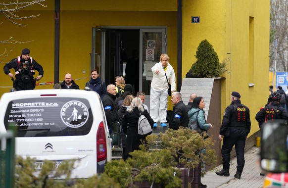 Members of Czech police forces stand in front of a school where a teacher was killed in Prague, Czech Republic, Thursday, March 31, 2022. Police in the Czech capital have arrested a suspect who allege ...
