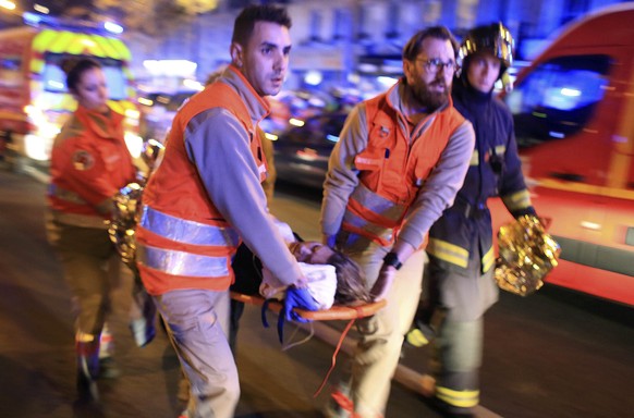 FILE - A woman is evacuated from the Bataclan concert hall after a shooting on Nov. 13, 2015 in Paris. The historic trial in Paris of 20 men suspected of critical roles in the Islamic State massacres  ...