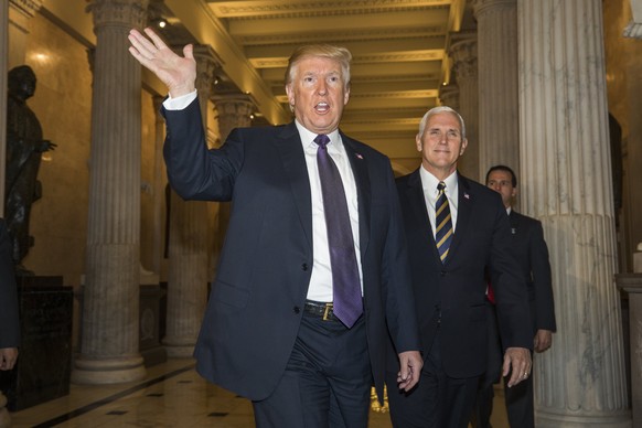 epa06333538 US President Donald J. Trump (L), along with Vice President Mike Pence (R), departs a Republican conference meeting in the House of Representatives to discuss the House&#039;s upcoming tax ...
