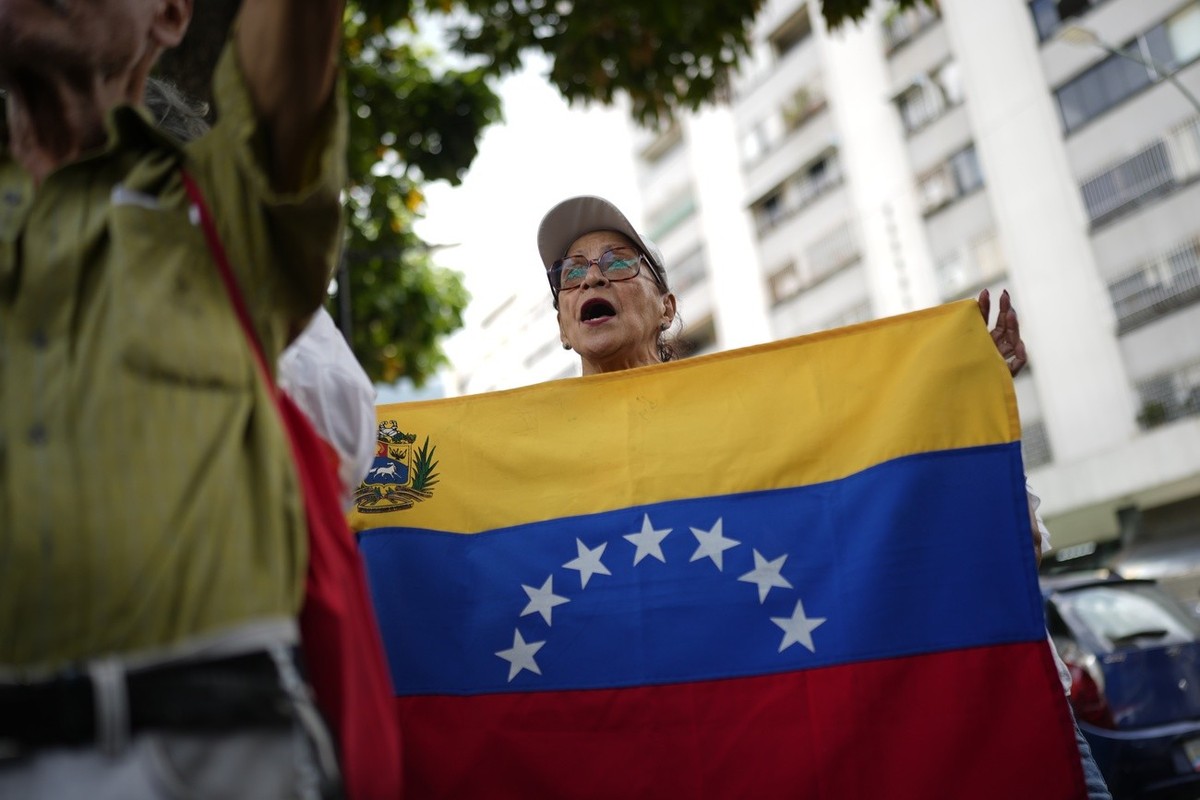 A woman holds a Venezuelan flag during a protest against the reelection of President Nicol