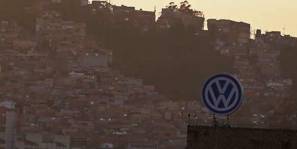 Das VW-Logo, im Hintergrund die Slums von Sao&nbsp;Bernardo do Campo in der Nähe von Sao Paolo.&nbsp;