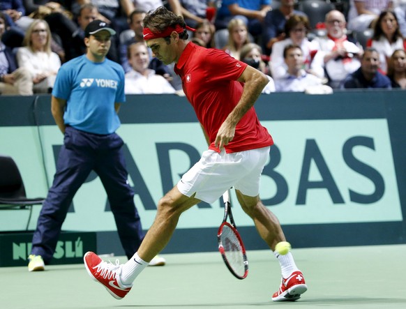 Switzerland&#039;s Roger Federer returns the ball between his legs during his Davis Cup World Group play-off tennis match against Jesse Huta Galung of the Netherlands at the Palexpo Arena in Geneva Se ...