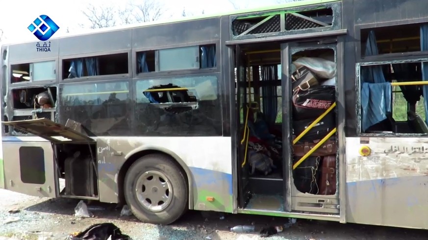 epa05909759 A handout photo made available by Thiqa News Agency (TNA) showing a damaged bus at the scene of a car bomb attack that targeted buses evacuating civilians from besieged towns, al-Rashideen ...