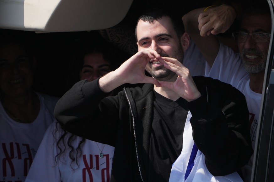 Freed Israeli hostage Guy Gilboa-Dalal gestures from a van as he arrives at Beilinson hospital in Petah Tikva, Israel, after he was released from Hamas captivity in the Gaza Stripl, Monday, Oct. 13, 2 ...