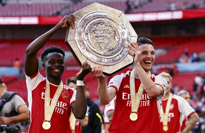 epa10788111 Bukayo Saka (L) and Declan Rise (R) of Arsenal celebrate with the trophy after winning the FA Community Shield soccer match between Arsenal London and Manchester City in London, Britain, 0 ...