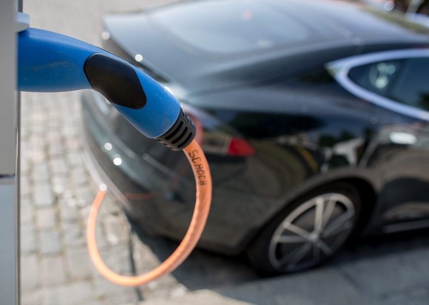 epa05314039 An electric vehicle is being charged at a charging station in Berlin, Germany, 18 May 2016. The German Federal Cabinet has initiated a program valued at one billion euro to promote electro ...