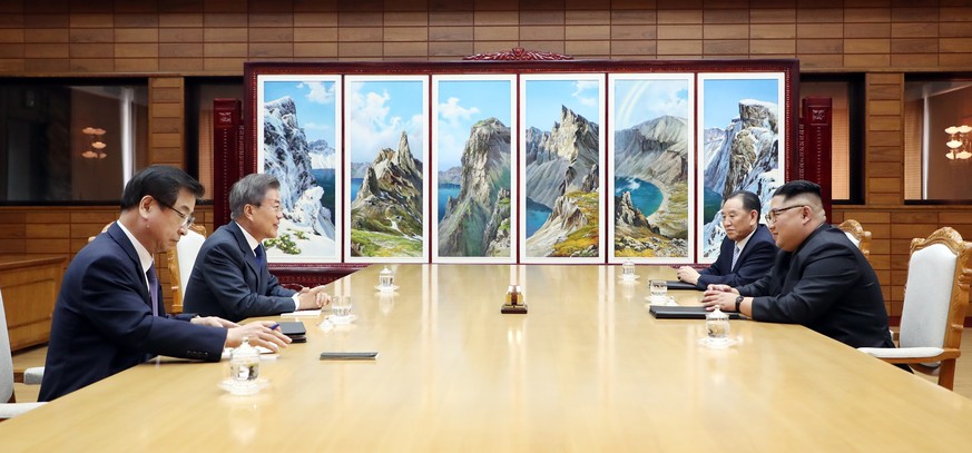 epa06764467 A handout photo made available by the South Korean presidential office Cheong Wa Dae (Blue House) shows South Korean President Moon Jae-in (2-L) speaking with North Korean leader Kim Jong- ...