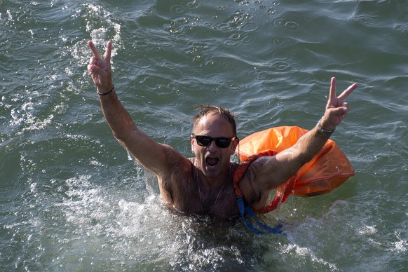 Ein Teilnehmer des 36. Basler Rheinschwimmens schwimmt und jubelt im Rhein in Basel am Dienstag, 16. August 2016. Die Schweizerische Lebensrettungs-Gesellschaft SLRG Basel fuehrt jeweils jaehrlich das ...