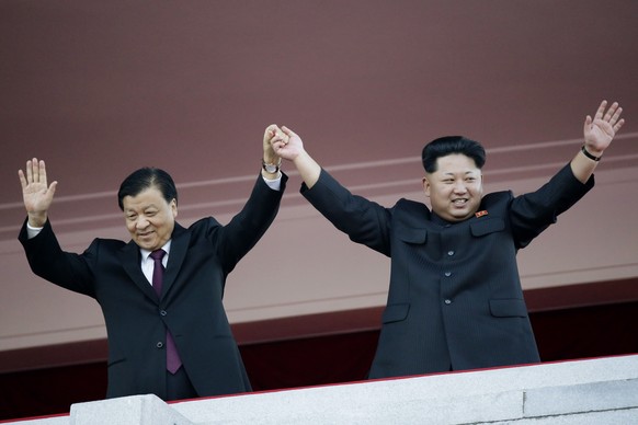 FILE - In this Oct. 10, 2015, file photo, North Korean leader Kim Jong Un, right, joins hands and waves with visiting Chinese official Liu Yunshan, the Communist Party&#039;s fifth-ranking leader, dur ...
