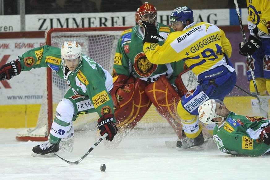 Die Langnauer Roman Schild, Goalie Benjamin Conz und Simon Luethi von links, im Kampf um den Puck gegen den Davoser Peter Guggisberg mitte, beim Eishockey Meisterschaftsspiel der National League A zwi ...