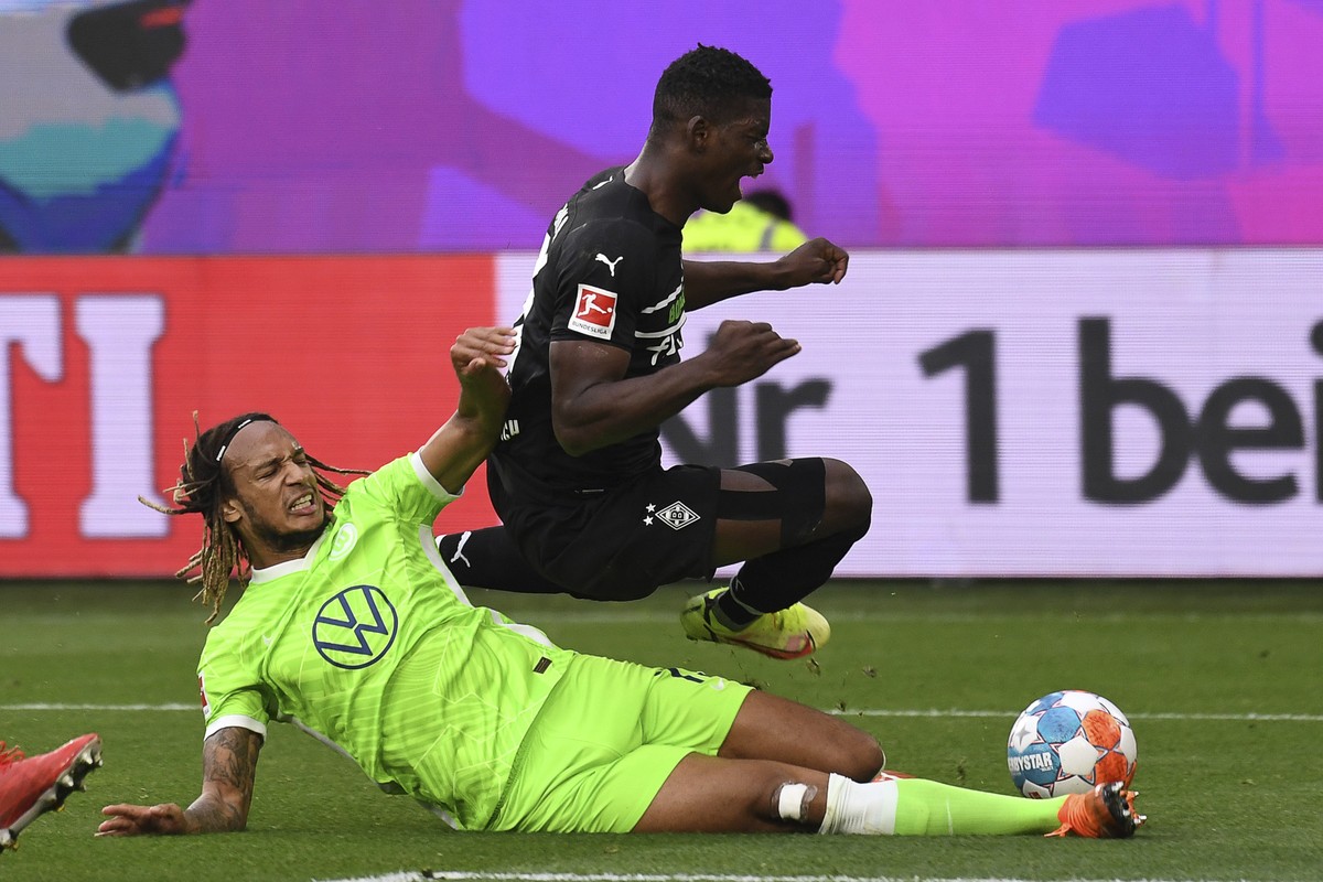 Wolfsburg's Kevin Mbabu, left, and Gladbach's Breel Embolo challenge for the ball during the German Bundesliga soccer match between VfL Wolfsburg and Borussia Moenchengladbach in Wolfsburg,  ...