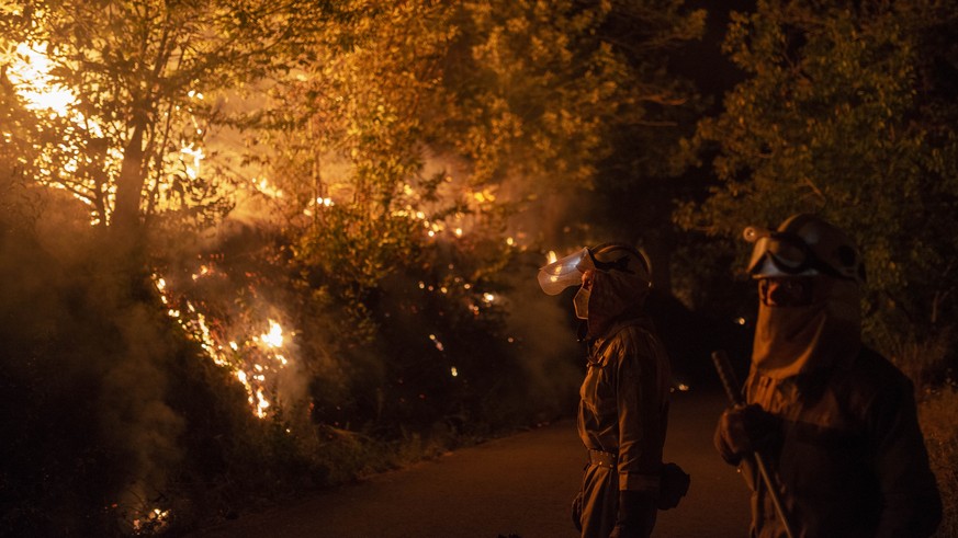 epa10077180 Firefighters in action during a forest fire in O Barco de Valdeorras, Galicia, northwestern Spain, 18 July 2022. The forest fire had destroyed some 2,400 hectares as of early 18 July. The ...