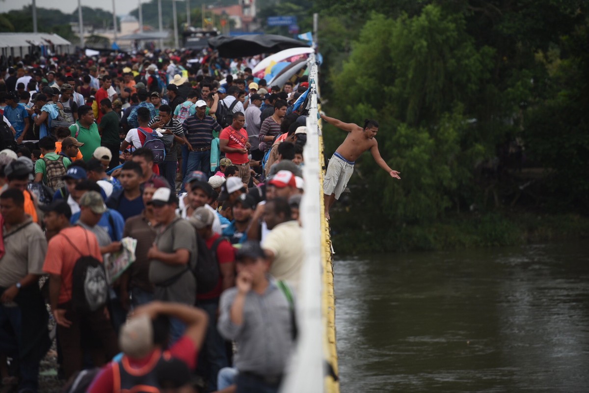 epaselect epa07107899 Honduran migrants jump in the Suchiate River in Tecun Uman, Guatemala, 20 October 2018, at the border between Mexico and Guatemala to enter Mexico while the immigration authoriti ...