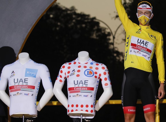 Slovenia&#039;s Tadej Pogacar, wearing the overall leader&#039;s yellow jersey, celebrates next to his two other jersey&#039;s, the best climber&#039;s dotted jersey and the best young rider&#039;s wh ...