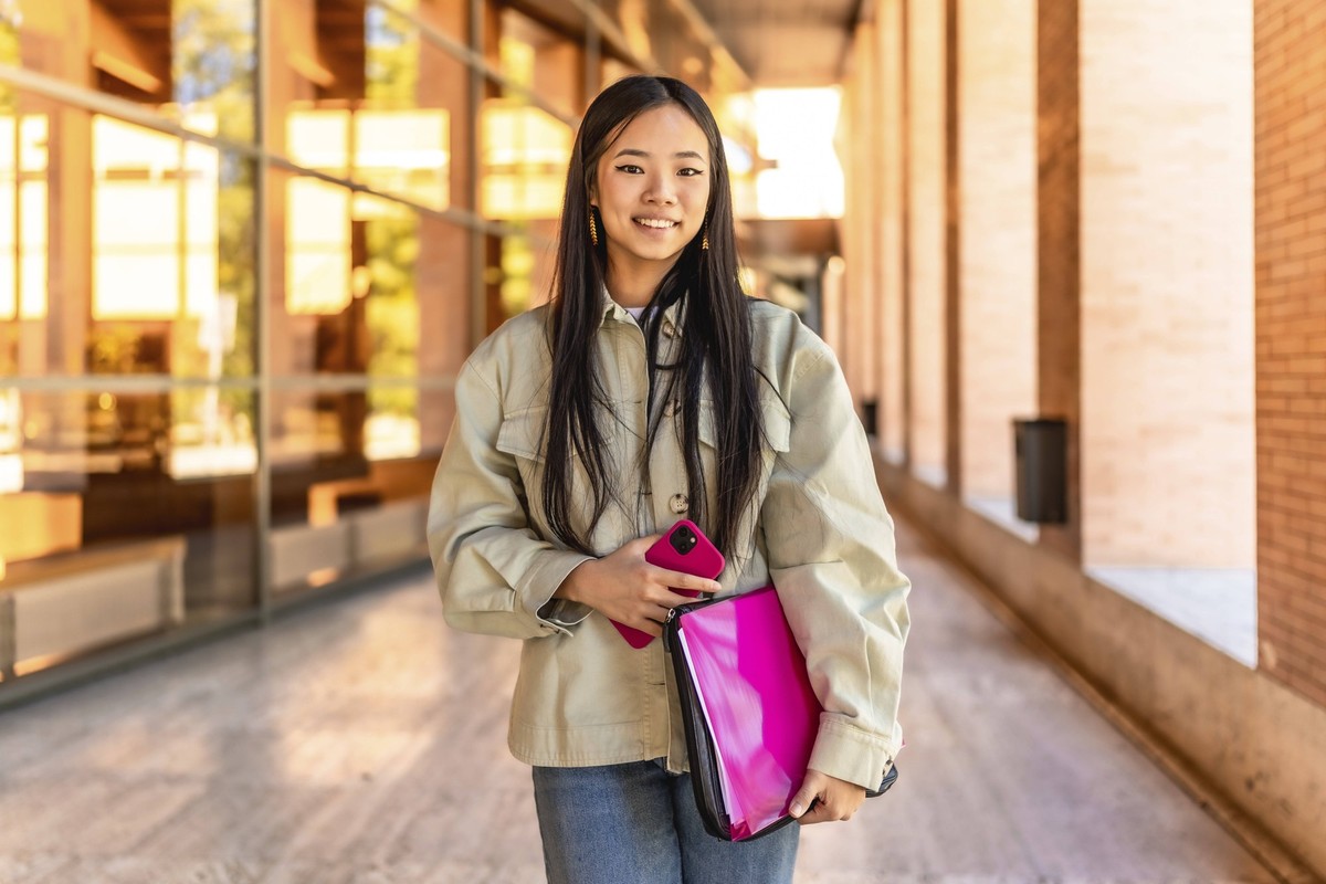Frontal Porträt einer chinesischen Schönheit Studentin stehend lächelnd in die Kamera an der Universität Frontal portrait of a chinese beauty female student standing smiling at camera at the universit ...