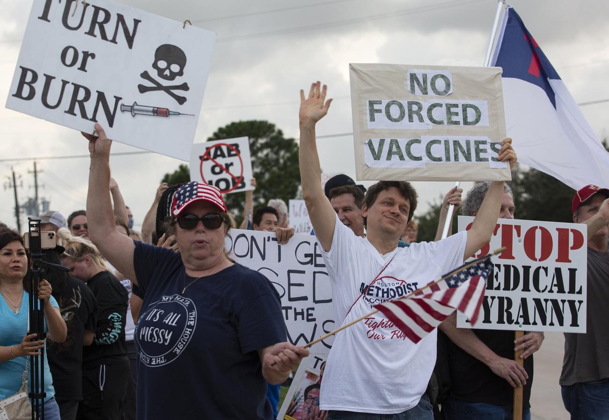 FILE - In this June 7, 2021, file photo, demonstrators at Houston Methodist Baytown Hospital in Baytown, Texas, wave at cars that honk at them to support their protest against a policy that says hospi ...