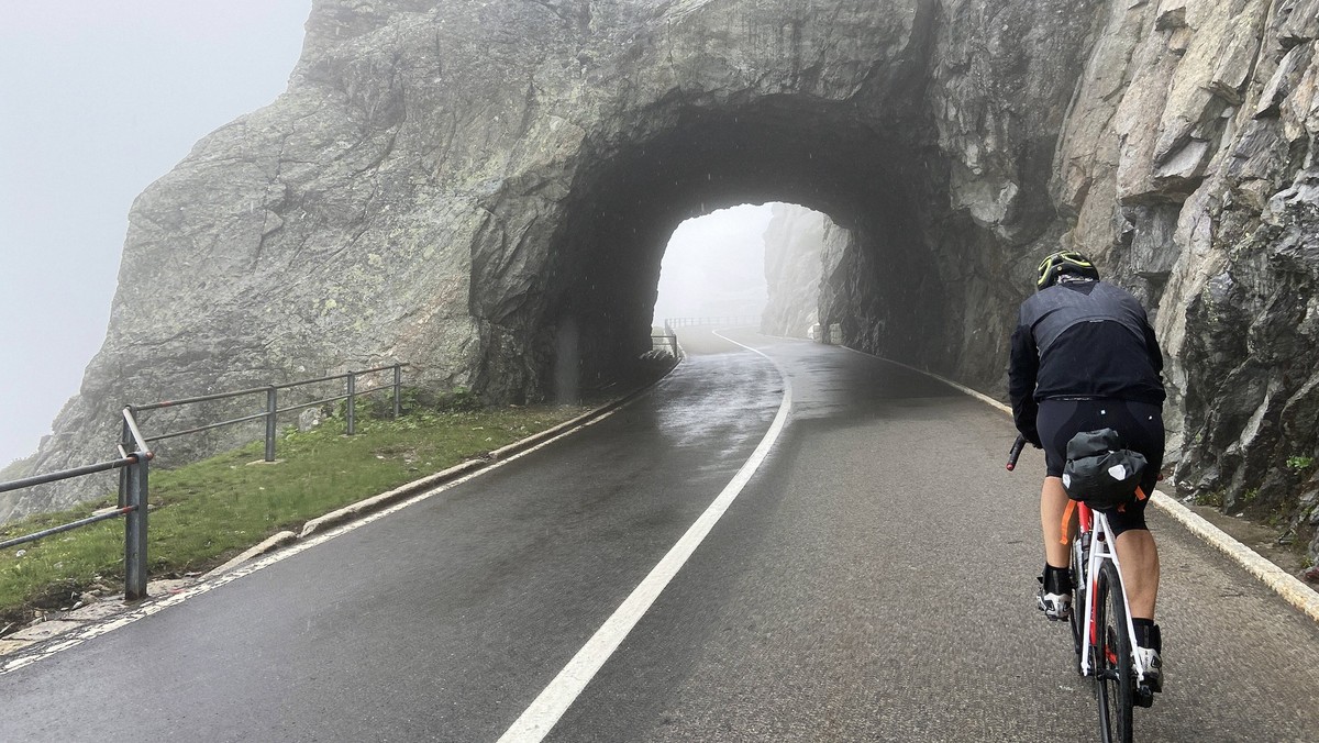 Rennradfahrer auf dem nebligen Sustenpass in den Schweizer Alpen, der die Kantone Uri und Bern verbindet, Schweiz. *** Racing cyclist on the misty Susten Pass in the Swiss Alps, which connects the can ...
