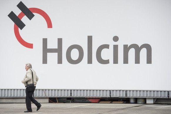 Ein Aktionaer laeuft vor einem Logo der Holcim an die ordentliche Generalversammlung der Holcim am Dienstag, 29. April 2014 in Duebendorf. (KEYSTONE/Ennio Leanza)