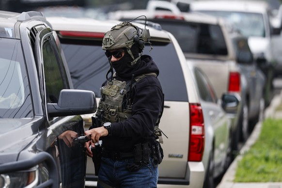 epa12669130 Immigration and Customs Enforcement agents and other law enforcement officials investigate a reported federal agent-involved shooting near the intersection of 126th Street and Mona Bouleva ...