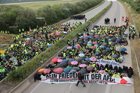 dpatopbilder - 04.07.2026, Thüringen, Erfurt: Demonstranten protestieren auf der Autobahn A71 bei Gottstedt gegen den AfD-Bundesparteitag. Der Bundesparteitag der AfD findet am 4. und 5. Juli in der M ...