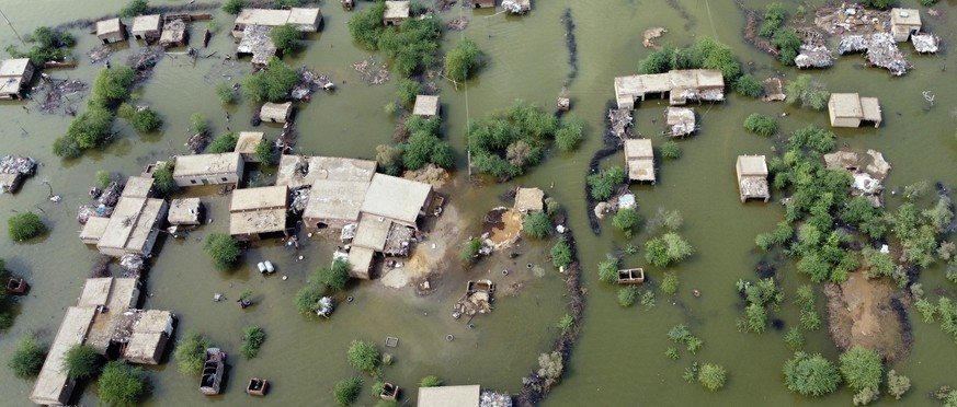 FILE - Homes are surrounded by floodwaters in Sohbat Pur city, a district of Pakistan&#039;s southwestern Baluchistan province, Aug. 30, 2022. This past year has seen a horrific flood that submerged o ...