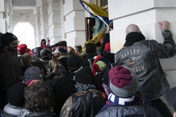 FILE - In this Jan. 6, 2021 file photo insurrectionists loyal to President Donald Trump try to open a door of the U.S. Capitol as they riot in Washington. New internal documents provided by former Fac ...