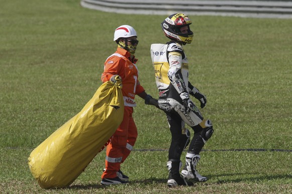 epa06294317 Swiss Moto2 rider Thomas Luthi of CarXpert Interwetten is assisted after crashing during the qualifying session at Sepang International Circuit, Malaysia, 28 October 2017. EPA/STR MALAYSIA ...